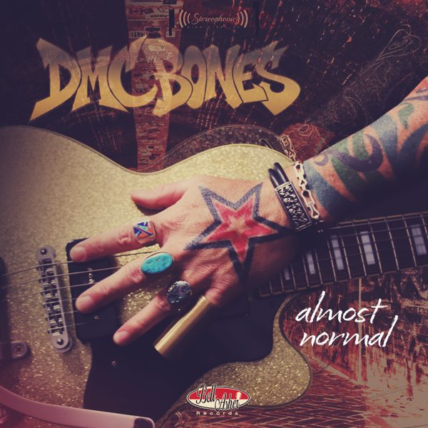 The almost normal cover: Danny’s tattooed hand with a red star and turquoise rings on a gold metal-flake guitar, under the gold DMCBONES wordmark
